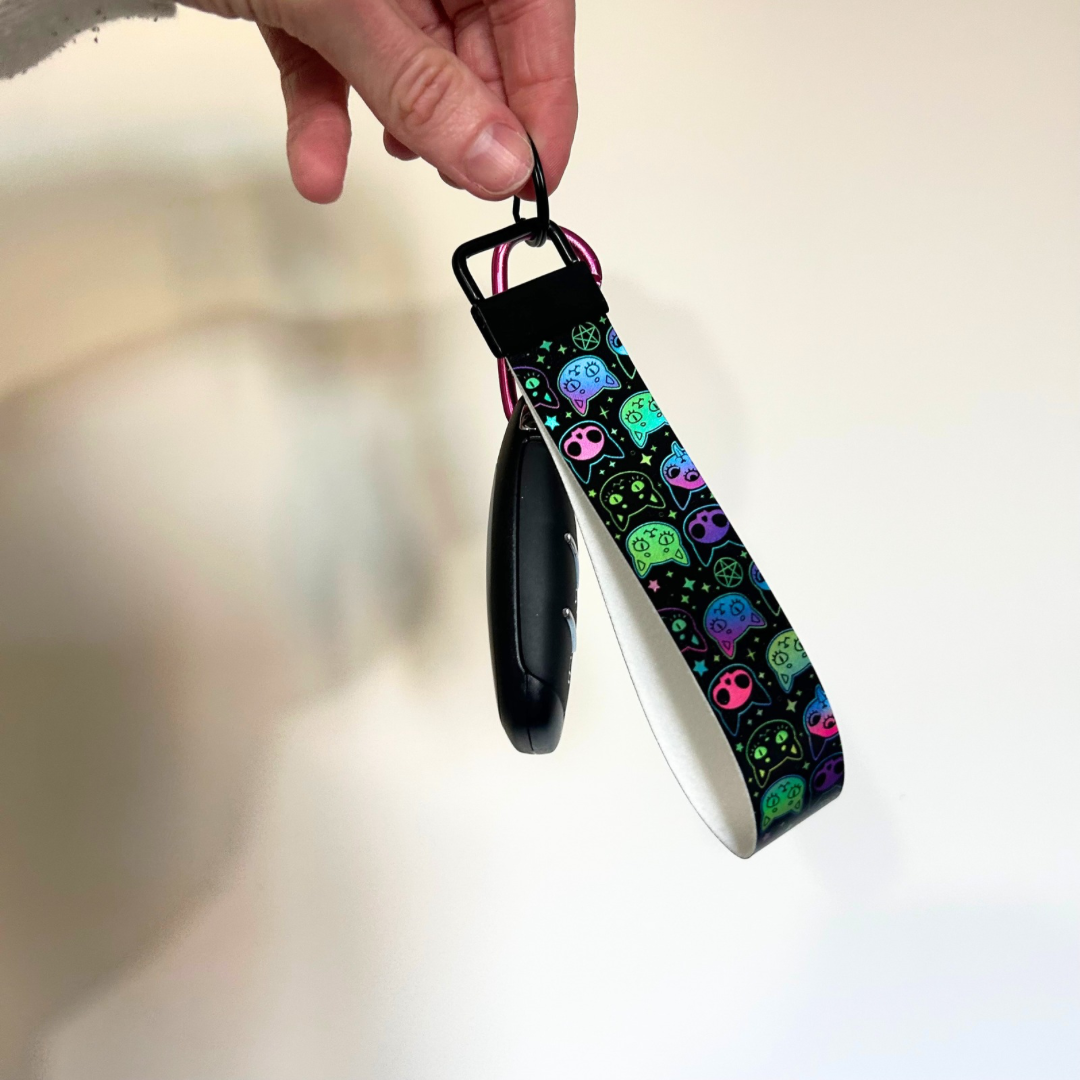 Black wristlet with black hardware, with holographic cat design 