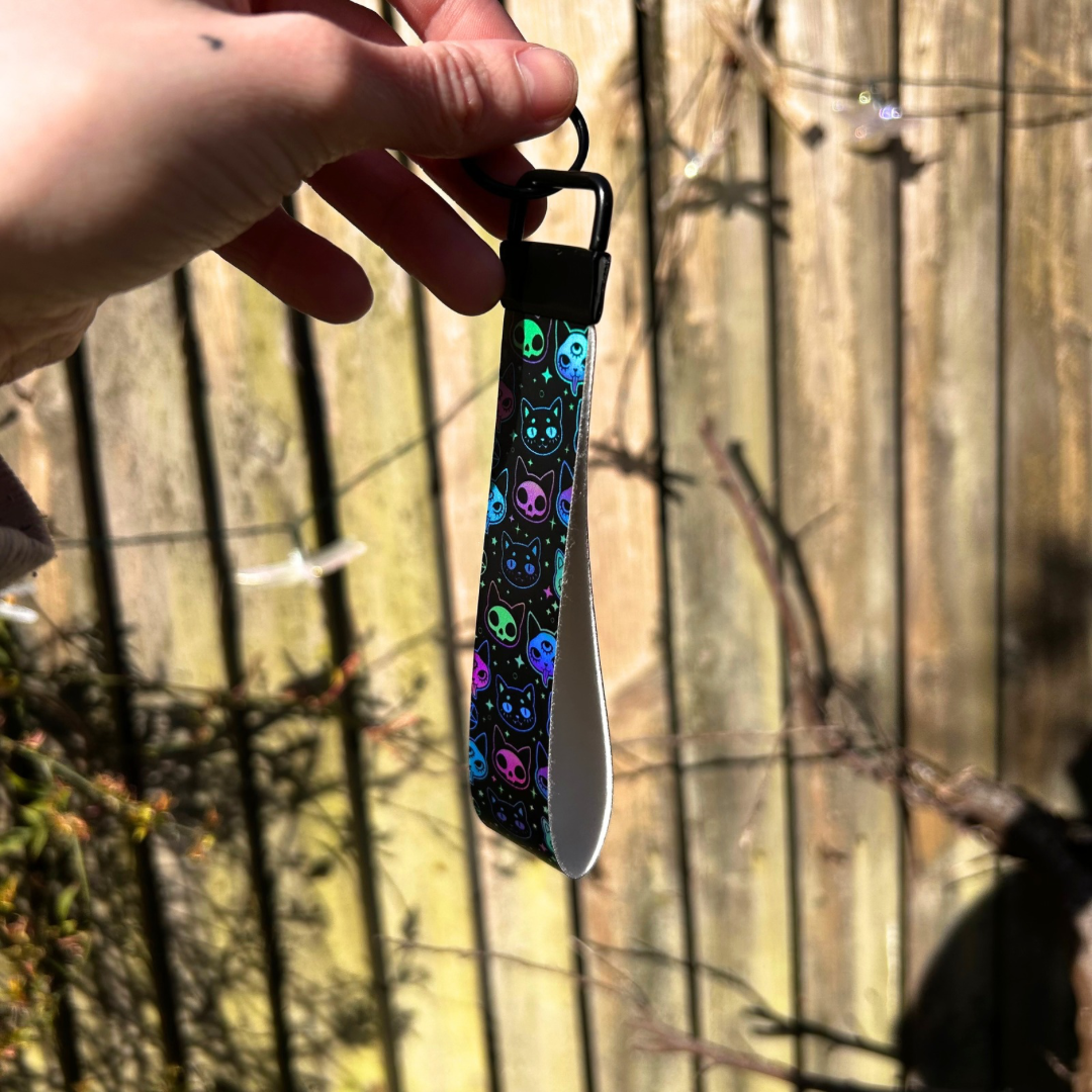 Black wristlet with black hardware, with holographic cat design 