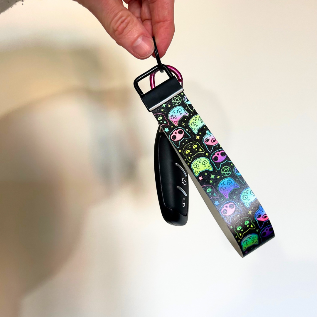 Black wristlet with black hardware, with holographic cat design 