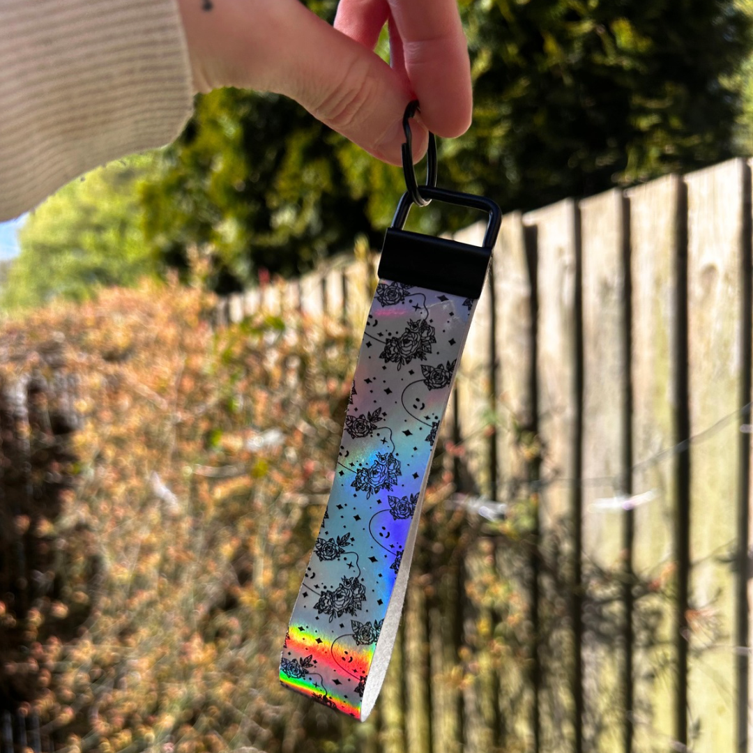 Colorful strap with floral pattern held by a person outdoors