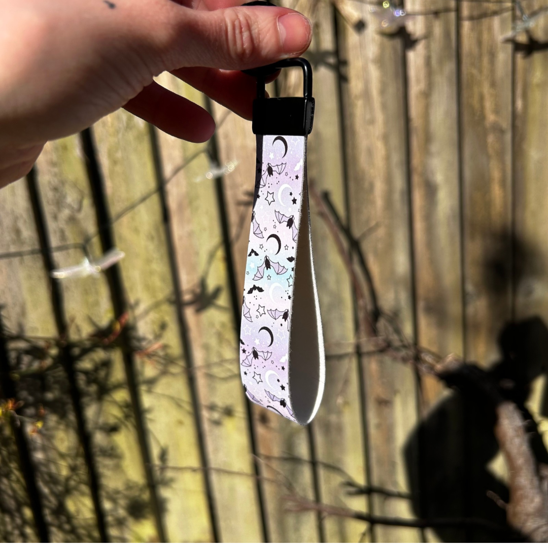 Pastle blue and pink wristlet with bat and moon design with black hardware