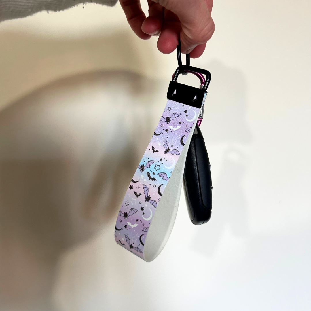 Pastle blue and pink wristlet with bat and moon design with black hardware